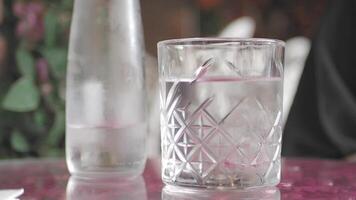 A Refreshing Glass of Water with Ice Cubes on a Table Setting, Perfect for Quenching Thirst video