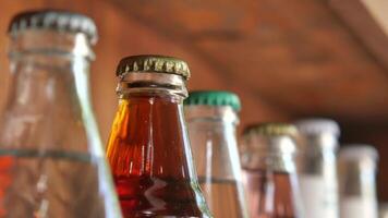Vintage beverage bottles with colorful caps on bar shelf create a nostalgic retro drinks display video