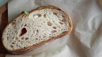 A beautifully textured slice of artisanal bread resting gently on rustic wrapping paper video