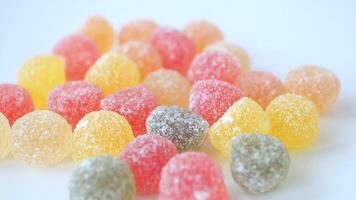 slow motion of dropping colorful fruit candies displayed on a pristine white background video