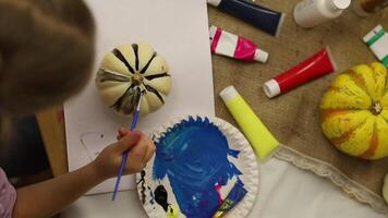 A cheerful 5-year-old girl paints with joy, her tiny hands skillfully applying colors to the canvas as she explores her creativity video