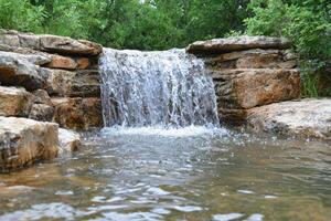 Serene waterfall in lush green forest photo