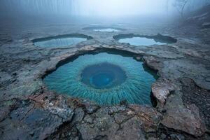 Mystical turquoise pools in a misty landscape photo