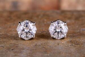 Elegant diamond stud earrings on a textured surface photo