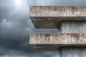 Concrete structure with weathered texture against cloudy sky photo