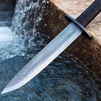 Closeup of a sharp knife blade with a waterfall in the background photo