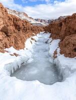 Frozen canyon landscape with icy stream photo