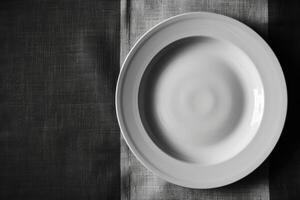 Empty white plate on dark textured background photo