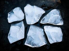 Jagged chunks of clear ice on a dark surface photo