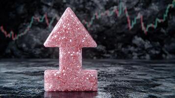 Sparkling pink crystal arrow pointing up on dark background photo