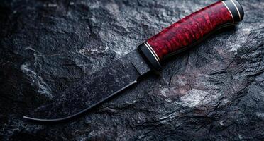 Sleek and sharp hunting knife on dark slate background photo