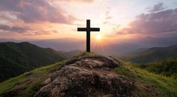 Silhouette of cross on mountain at sunset photo
