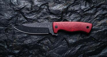 Closeup of a sharp hunting knife with a red wooden handle photo