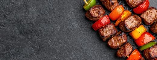Grilled meat and vegetable skewers on dark background photo