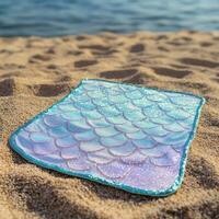 Glittering mermaid tail on sandy beach photo
