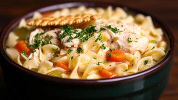 A bowl of chicken noodle soup with vegetables photo