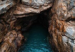 Mysterious cave entrance with turquoise water photo