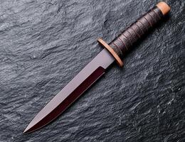 Sleek and Powerful Hunting Knife on Dark Stone Background photo