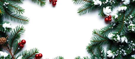 green pine branches with red ornaments faux snow form a festive frame photo