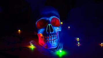 blue ceramic skull illuminated with colorful lights photo