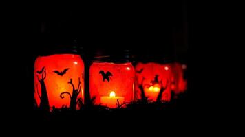 glowing halloween jars with bat tree silhouettes photo