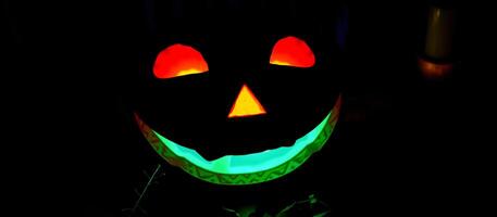 glowing carved pumpkin with a green rim photo
