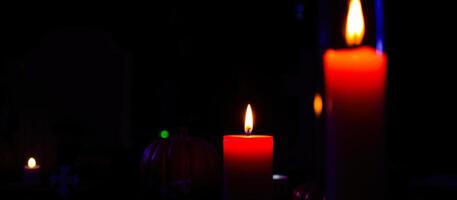 three red candles glowing the dark photo