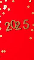 golden 2025 numbers on red background with confetti photo