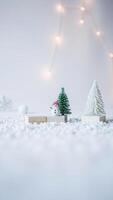 miniatura monigote de nieve soportes un Nevado paisaje con festivo luces foto