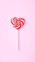 single heart-shaped lollipop on a pink background photo