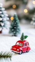 miniature red car carrying a tiny evergreen tree a snowy setting photo