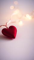 single red heart ornament on a white background with blurry string lights photo