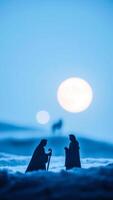 two silhouettes stand under a full moon photo