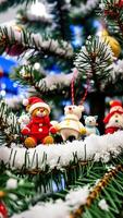 rojo osito de peluche oso vistiendo un Papa Noel sombrero se sienta en un cubierto de nieve hojas perennes rama foto