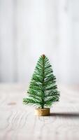 miniature artificial evergreen tree on a light wood table photo