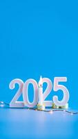 lit candle illuminates the year 2025 photo