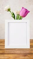 white frame with flowers on a rustic wooden table photo