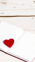 red heart resting on an open notebook photo
