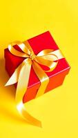 red gift box with a golden bow on a yellow background photo