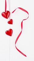 three red glass hearts hanging with a red ribbon photo