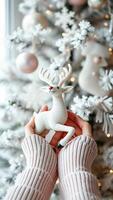 pair hands holding a white reindeer figurine photo