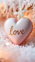 pink heart ornament with a snowflake resting on faux snow photo