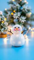 blanco monigote de nieve con un simpático cara soportes en contra un borroso antecedentes escarchado verdor calentar luces foto