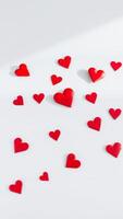 red hearts scattered on white background photo