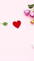 red felt heart on a soft pink background with flowers photo