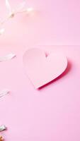 single pink paper heart on a pink background photo