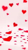 red hearts falling on a white surface photo