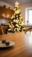 two pine cones on a wooden table with a blurred christmas tree background photo