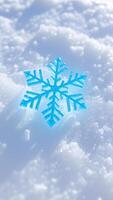 blue sparkly snowflake rests on white snow photo