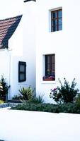 white building with a tiled roof a garden photo